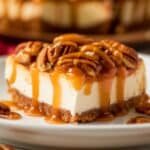 A luscious slice of Pecan Pie Cheesecake Recipe with a buttery graham cracker crust, creamy cheesecake filling, topped with crunchy pecans and drizzled with rich caramel sauce. The perfect indulgent dessert for any occasion.