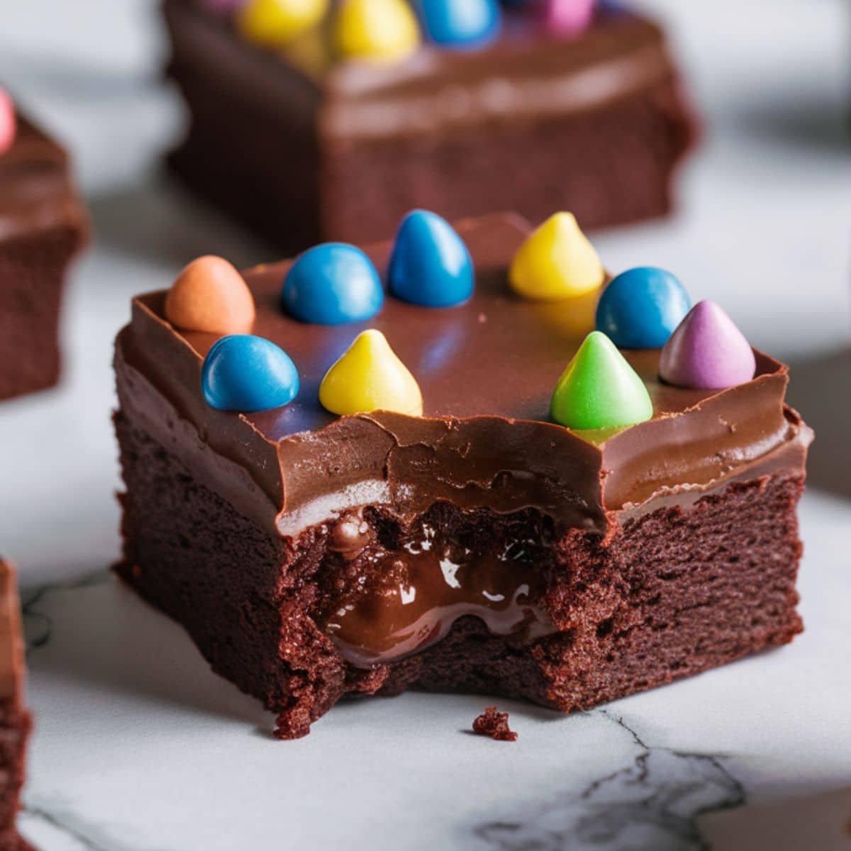 Decadent homemade Cosmic Brownie with a rich, fudgy center, topped with smooth chocolate frosting and colorful candy-coated sprinkles. This chocolate brownie recipe delivers a chewy, gooey texture with a glossy ganache finish. The perfect easy dessert for chocolate lovers!
