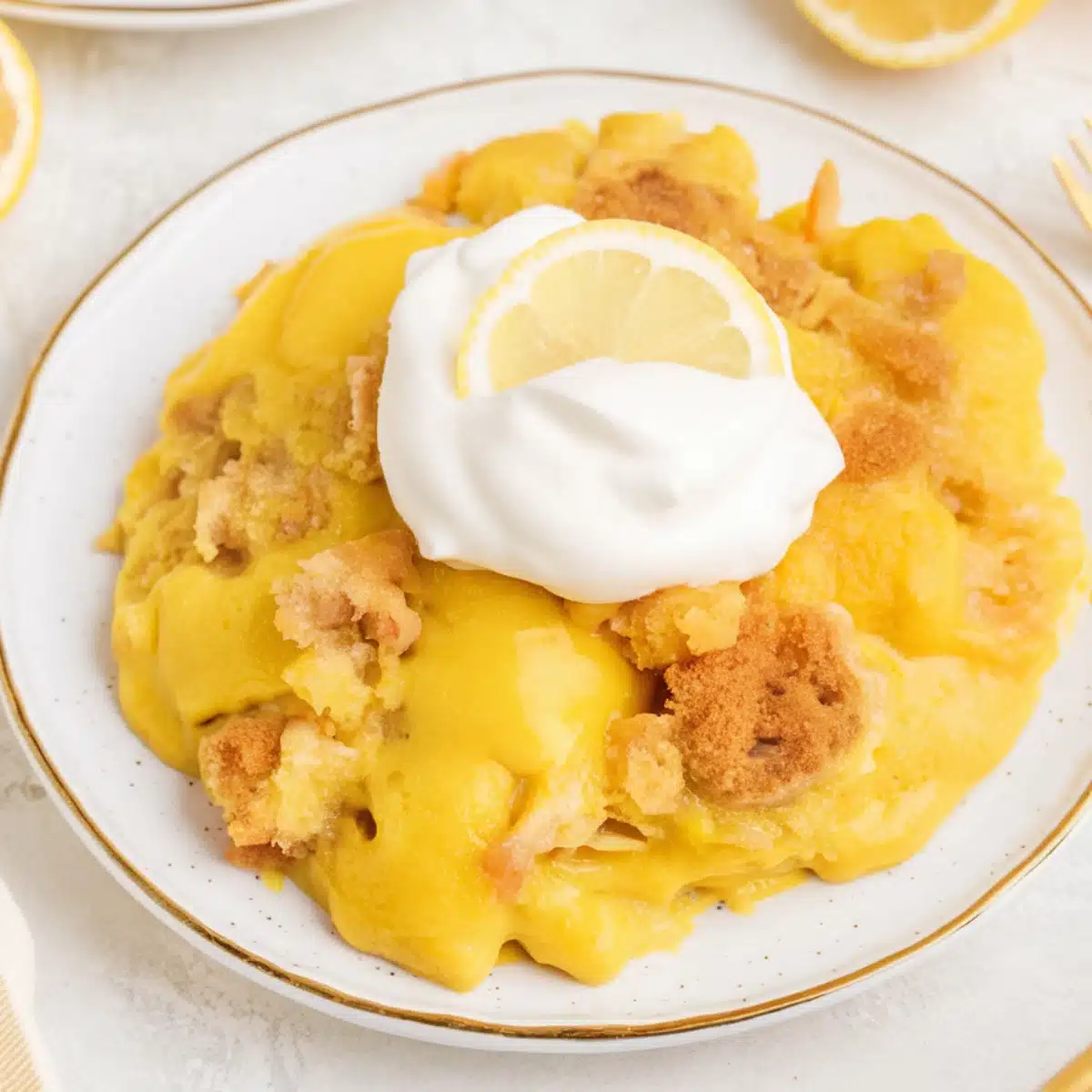 Lemon Dump Cake Recipe – A warm and gooey lemon dessert featuring a golden, crumbly cake topping over a rich, tangy lemon pie filling. Served on a white plate, garnished with a dollop of whipped cream and a fresh lemon slice. A simple, delicious, and refreshing treat perfect for any occasion.