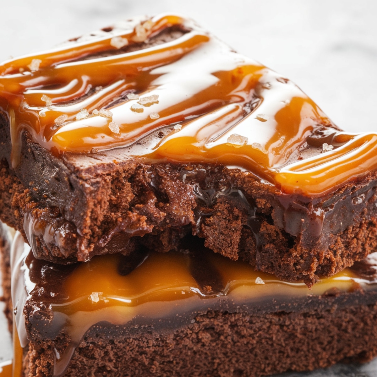 A close-up of fudgy caramel brownies with a rich chocolate base, gooey caramel drizzle, and a sprinkle of sea salt. This homemade caramel brownie recipe delivers a perfect balance of sweet and salty flavors, making it an irresistible dessert for chocolate lovers.
