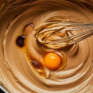 Beat in egg, vanilla extract, and almond extract (if using) until well combined.