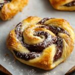 Golden, flaky homemade Nutella puff pastry swirled with rich chocolate hazelnut spread and dusted with powdered sugar.