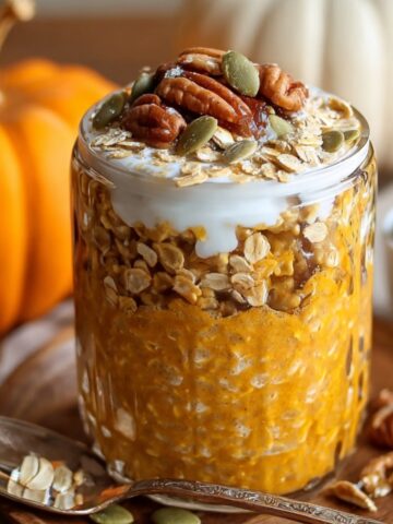 Healthy Pumpkin Overnight Oats Recipe in a jar topped with yogurt, pecans, pumpkin seeds, and granola.
