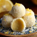Homemade lemon truffles coated in coconut with creamy lemon filling.