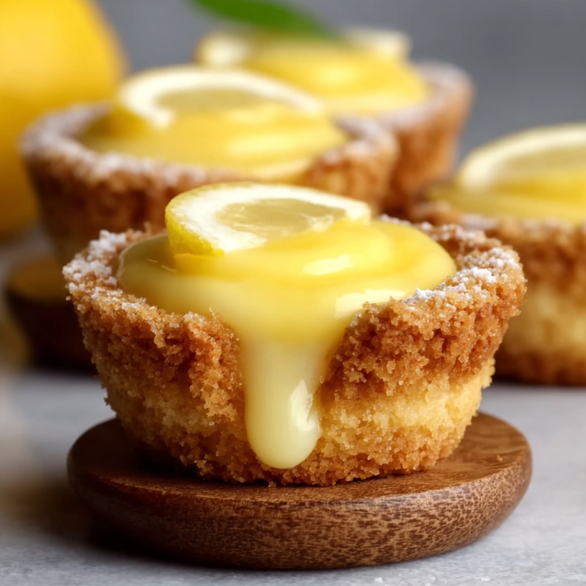 Homemade lemon curd cookie cup topped with whipped cream and a fresh lemon slice on a marble surface.