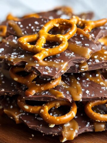 Homemade Salted Caramel Pretzel Bark, showing jagged pieces of dark chocolate coated in gooey caramel, topped with whole crunchy pretzels and sprinkled with flaky sea salt.