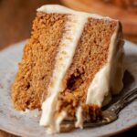 Brown Sugar Chai Cake Recipe with creamy frosting, with a bite taken out and a fork beside it.