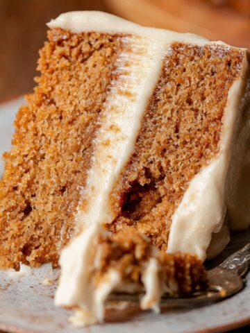 Brown Sugar Chai Cake Recipe with creamy frosting, with a bite taken out and a fork beside it.
