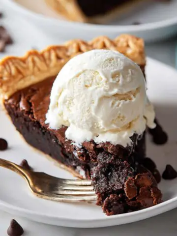 Chocolate brownie pie slice with a scoop of vanilla ice cream.