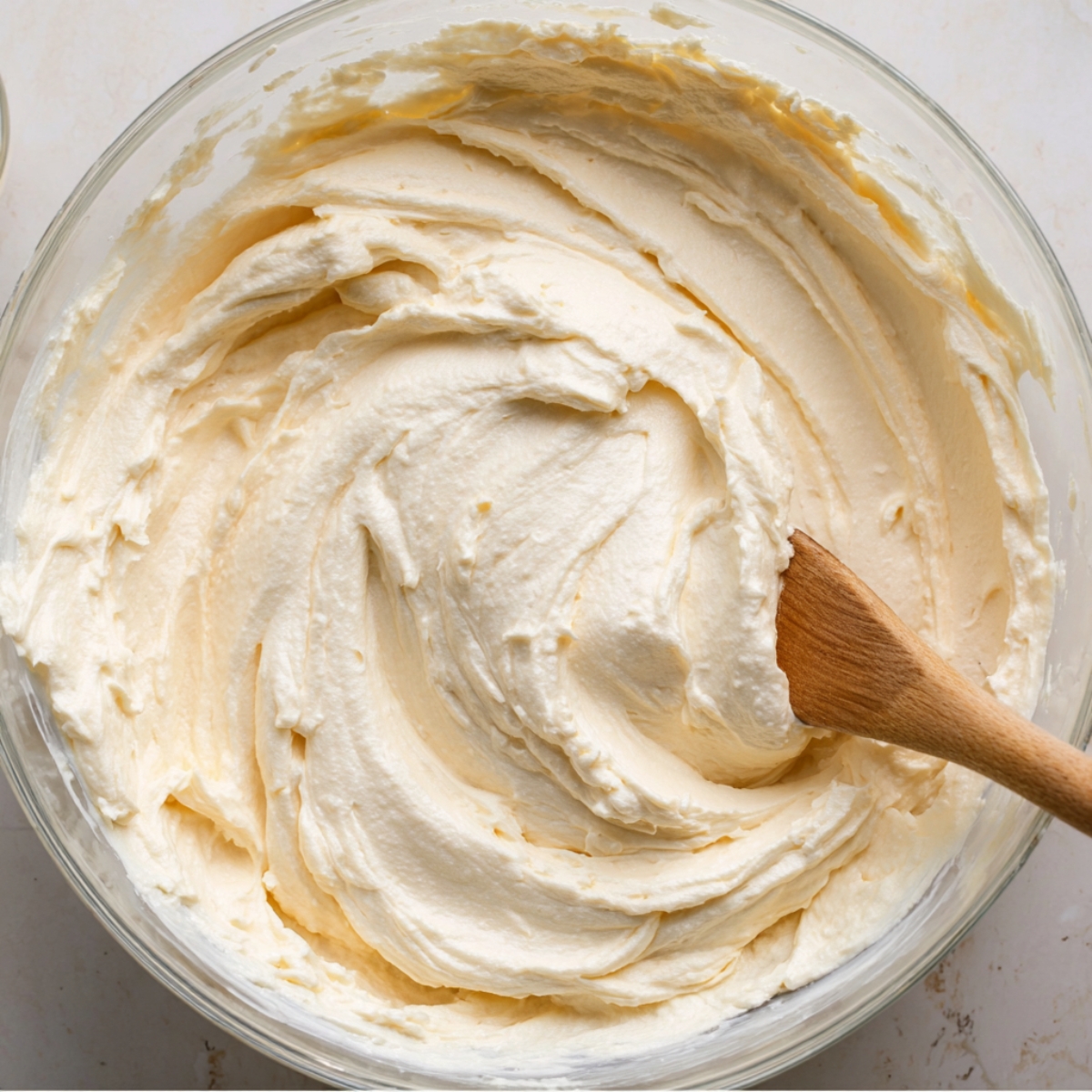 Gently fold the whipped cream into the cream cheese mixture in three additions. Use a spatula and fold from the bottom up, turning the bowl as you go. Stop as soon as everything is combined and you don't see any white streaks.