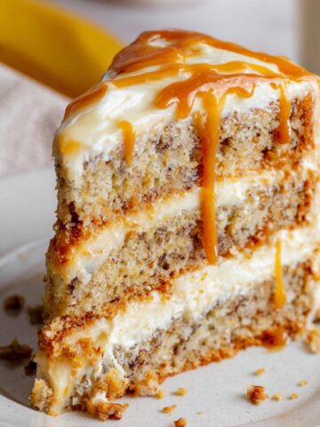 Homemade Banoffee Cake with banana sponge, cream layers, and caramel drizzle.