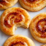 Homemade Creme Brûlée Cookies with a caramelized swirl, one with a bite taken out to reveal its soft interior.
