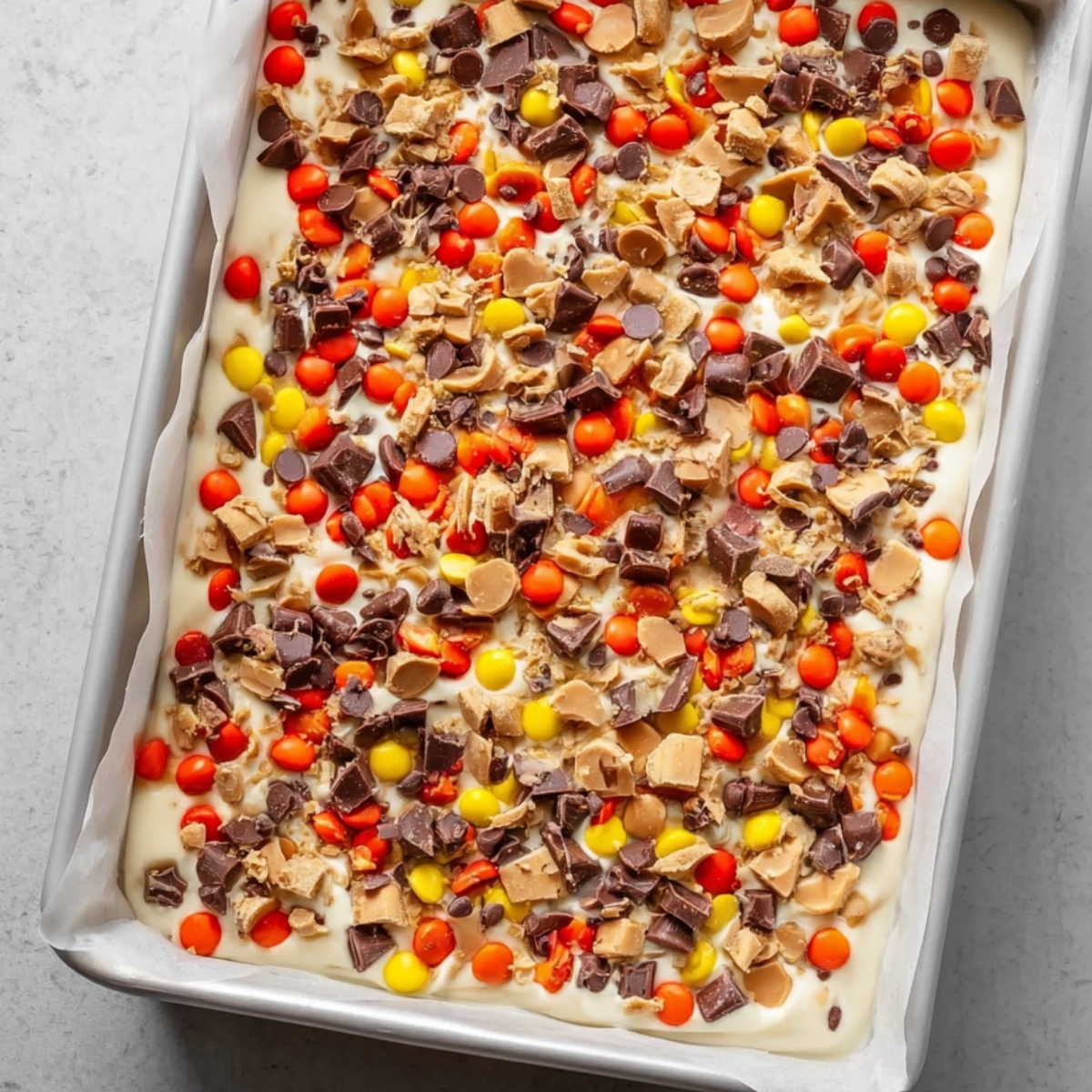 Peanut Butter White Chocolate Bark 12 Topped with Reese's Pieces on the peanut butter chocolate mixture.