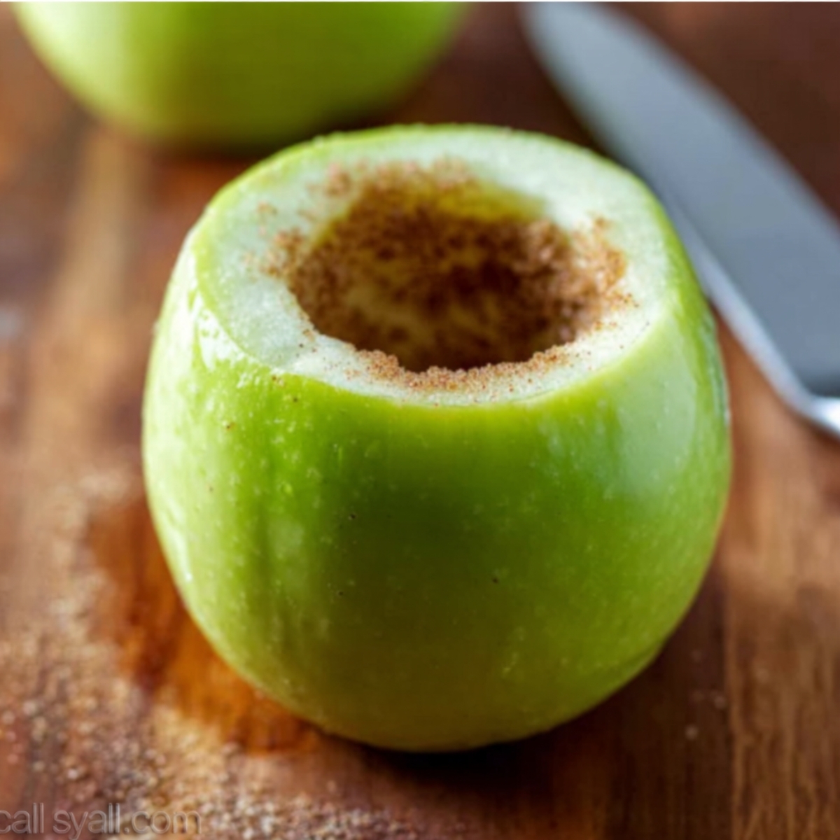 Apple Pie Baked Apples 11 A green apple, hollowed out and sprinkled with cinnamon, ready to be filled with a sweet apple pie filling and baked into a delicious dessert.
