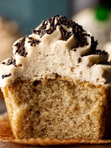 Delicious Baileys and Coffee Cupcakes 13 A close-up of a freshly baked Baileys and Coffee Cupcakes with fluffy buttercream frosting topped with chocolate sprinkles, showcasing its soft crumb.