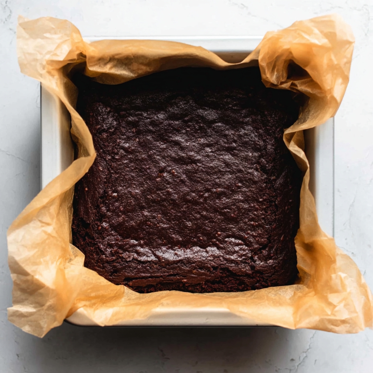 Brownie Ice Cream Sandwiches Recipe | Fudgy & Easy 11 Baked chocolate brownie layer cooling in a square baking pan.