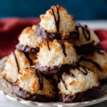 A close-up of coconut macaroons, dipped in dark chocolate and drizzled with more chocolate.