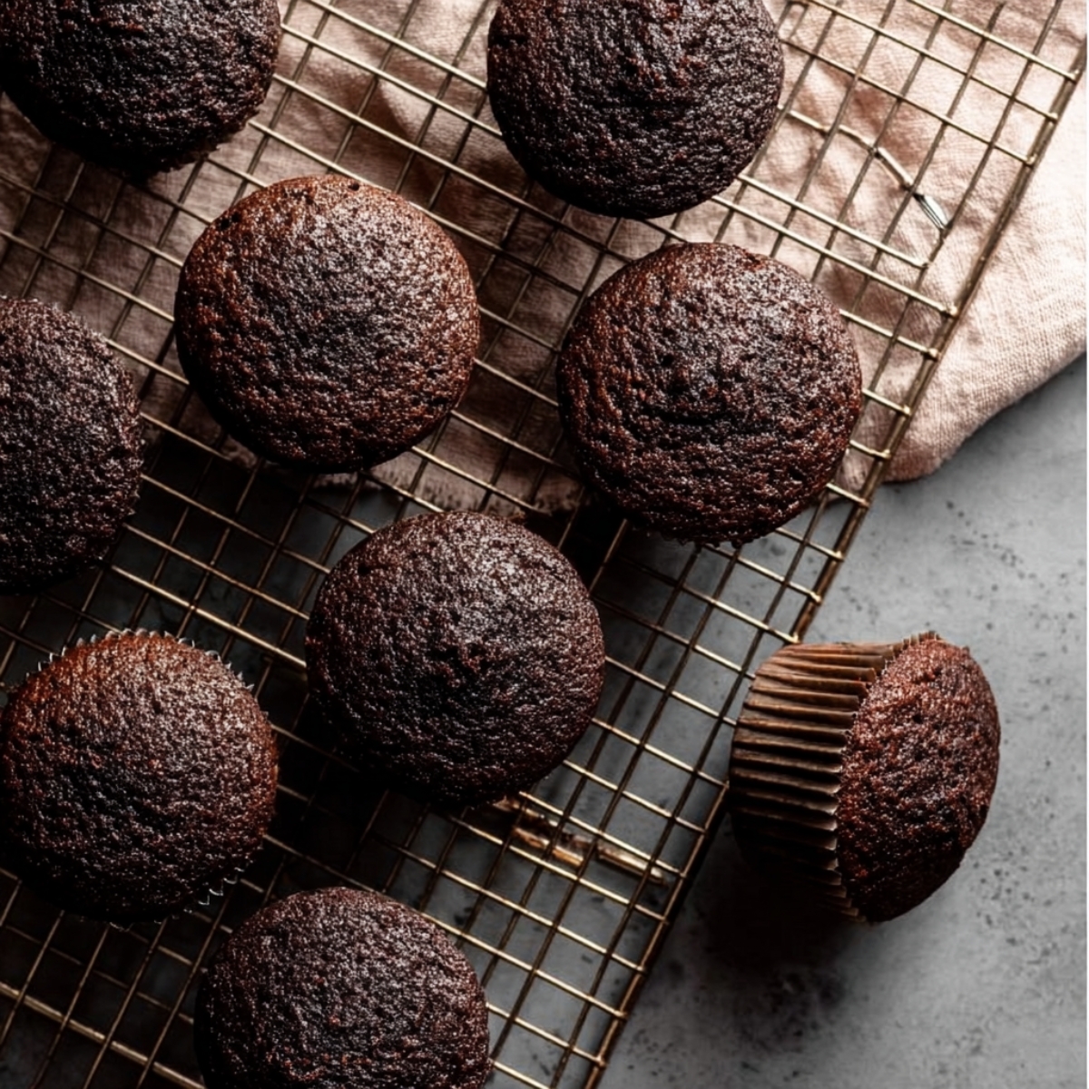 Cream-Filled Chocolate Cupcakes 12 Freshly baked chocolate cupcakes cooling on a wire rack before filling and frosting