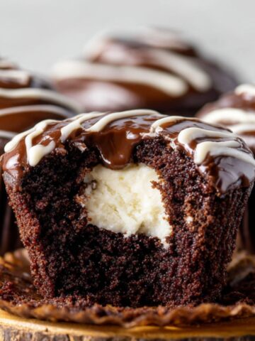 Cream-Filled Chocolate Cupcakes 8 Cream-Filled Chocolate Cupcakes with vanilla cream filling and chocolate ganache topping, cut open to show center