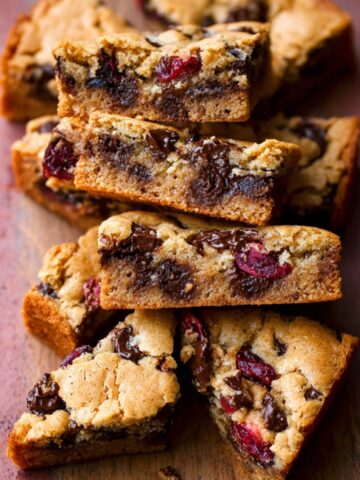 Sliced Dark Chocolate Cranberry Blondies on a piece of parchment paper.