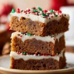 Homemade Gingerbread Cookie Bars with a thick layer of white frosting, decorated with colorful sprinkles on top.