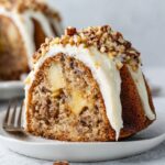Close-up of moist Hummingbird Bundt Cake slice with pineapple chunks and cream cheese icing