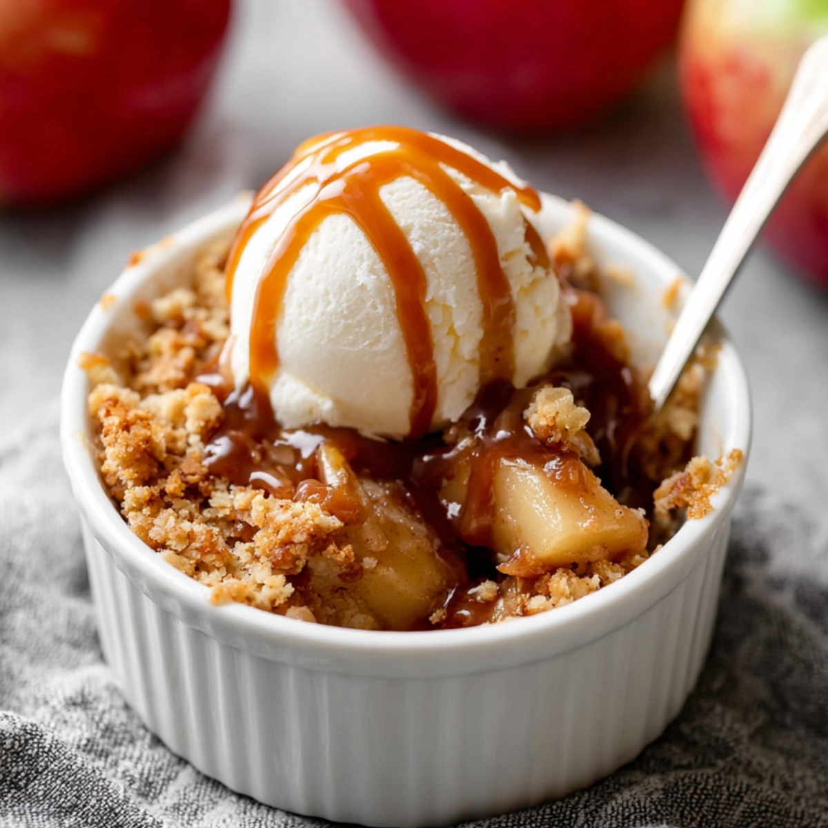 Individual Apple Crumbles Recipe 9 Individual Apple Crumbles topped with vanilla ice cream and caramel sauce.