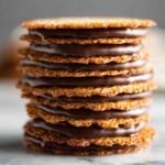 Close-up of stacked lace cookies filled with smooth chocolate.