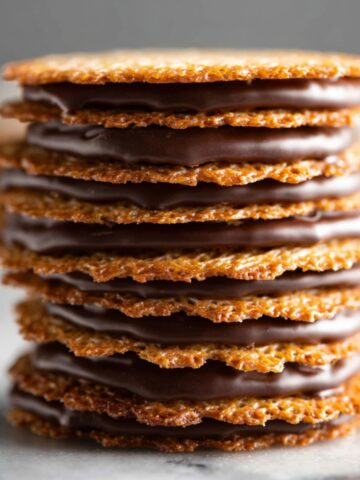 Close-up of stacked lace cookies filled with smooth chocolate.