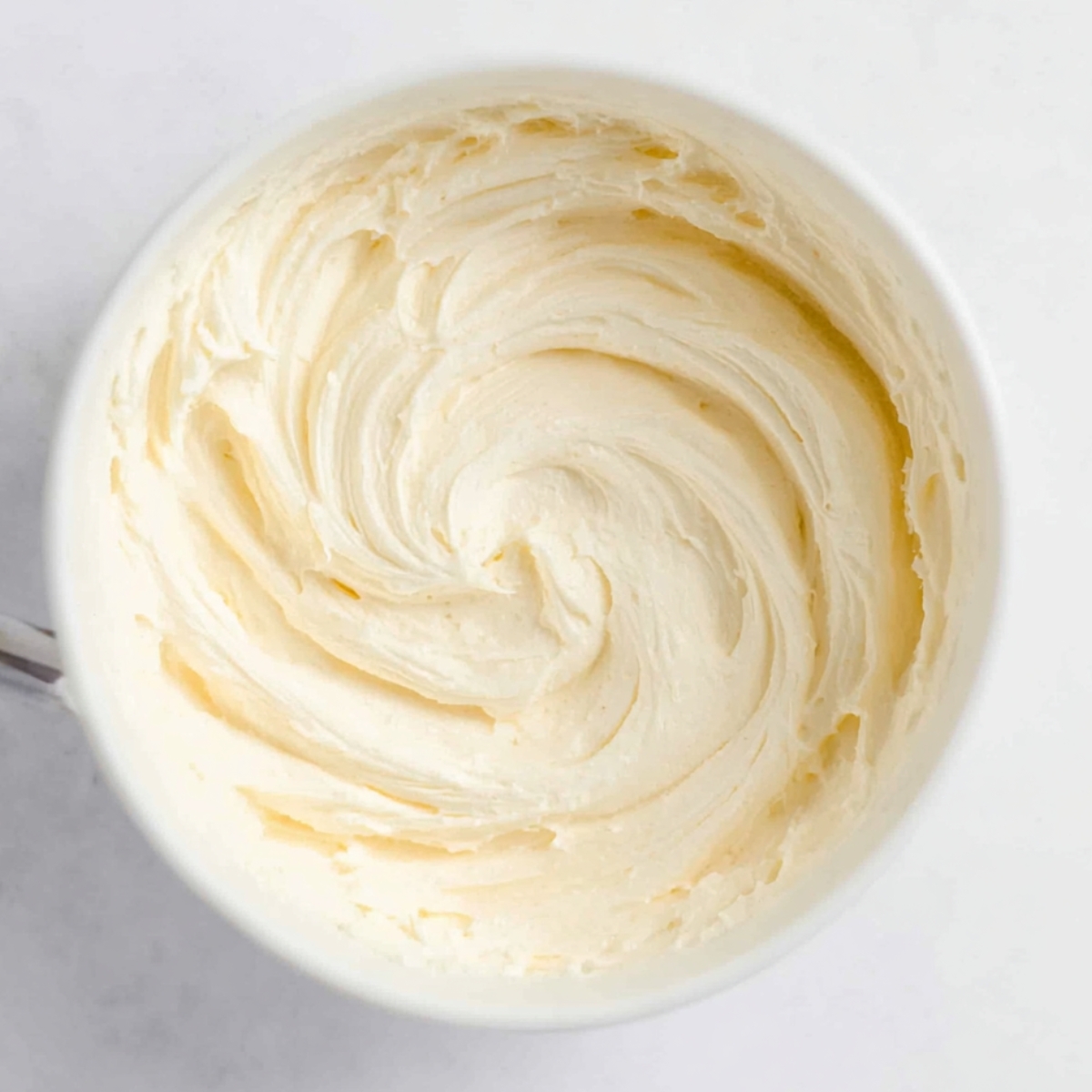 Fudgy Heart Shaped Brownies 11 A smooth and creamy cheesecake topping swirled to perfection in a bowl, ready to be spread over desserts.