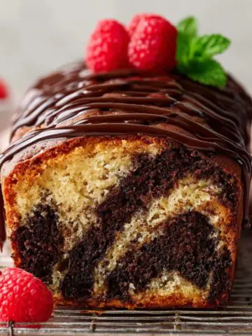 Marble Loaf Cake Recipe with raspberries on top.