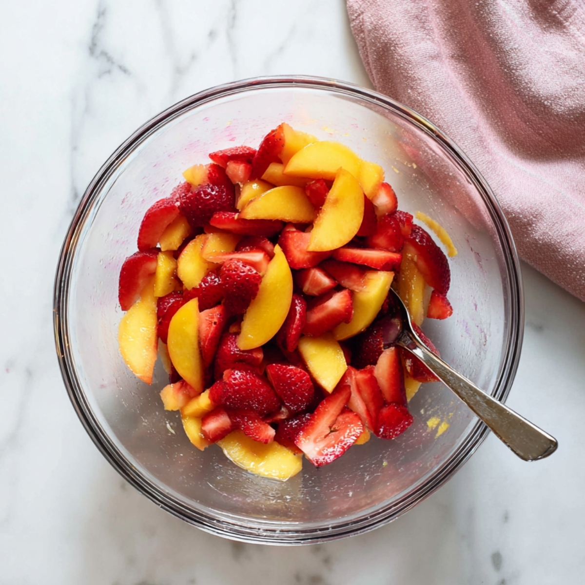 Easy Strawberry Peach Galette Recipe 10 Sliced strawberries and peaches mixed in a glass bowl for galette filling with a spoon