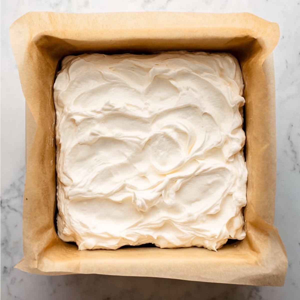 Brownie Ice Cream Sandwiches Recipe | Fudgy & Easy 12 Creamy ice cream layer spread in a parchment-lined square pan.