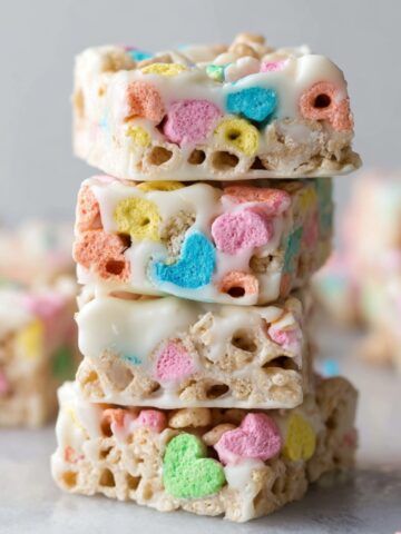 The Best White Chocolate Lucky Charms Treats 3 Stacks of White Chocolate Lucky Charms Treats with pastel-colored marshmallows.