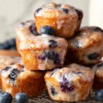 Baked Blueberry Fritter Bites, glazed with a sweet syrup, with visible blueberries peeking through the golden brown muffins.
