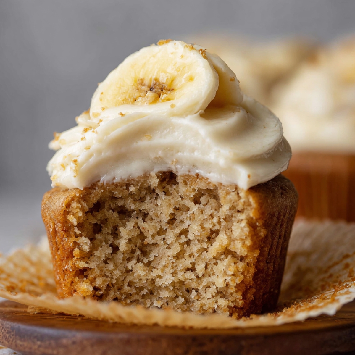 The Best Banana Cupcakes Recipe 9 Banana Cupcakes with cream cheese frosting topped with a banana slice and crumbled graham crackers.