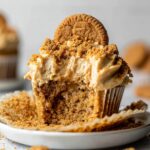 Close-up of a bowl filled with Biscoff Cupcakes, showing the chocolate-covered exterior with a bite taken out revealing the smooth peanut butter filling.