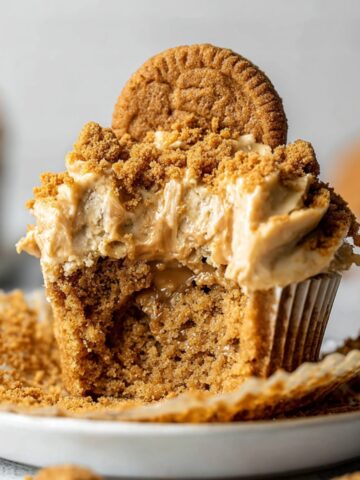 The Best Biscoff Cupcakes Recipe 1 Close-up of a bowl filled with Biscoff Cupcakes, showing the chocolate-covered exterior with a bite taken out revealing the smooth peanut butter filling.