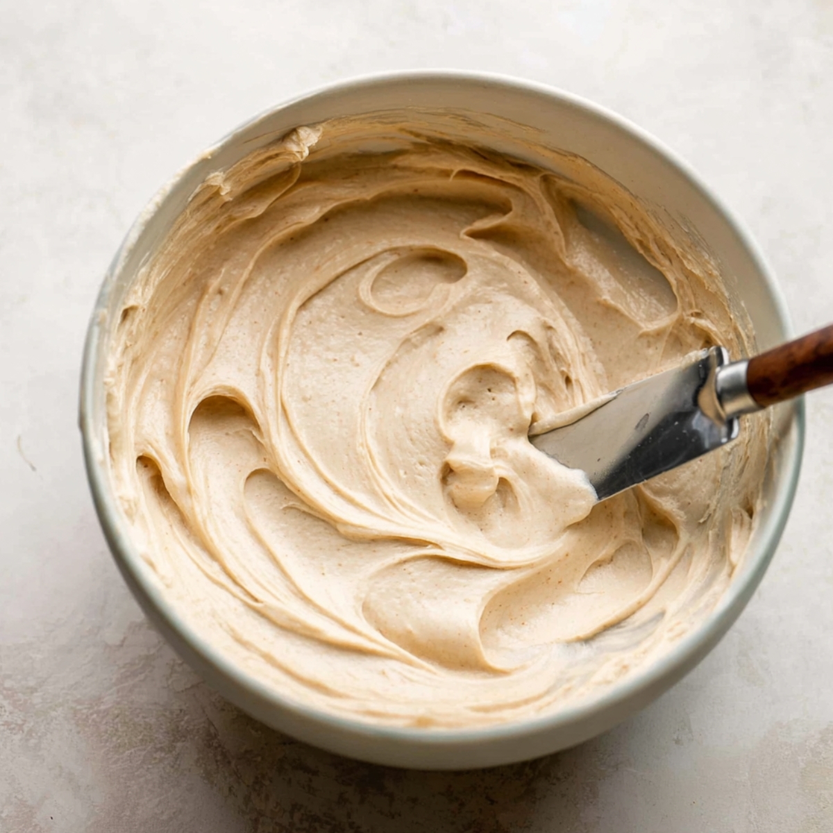 Healthy Zucchini Cake Recipe 11 Smooth and creamy frosting ready to be spread over a freshly baked cake, offering a soft and velvety texture with a hint of sweetness.