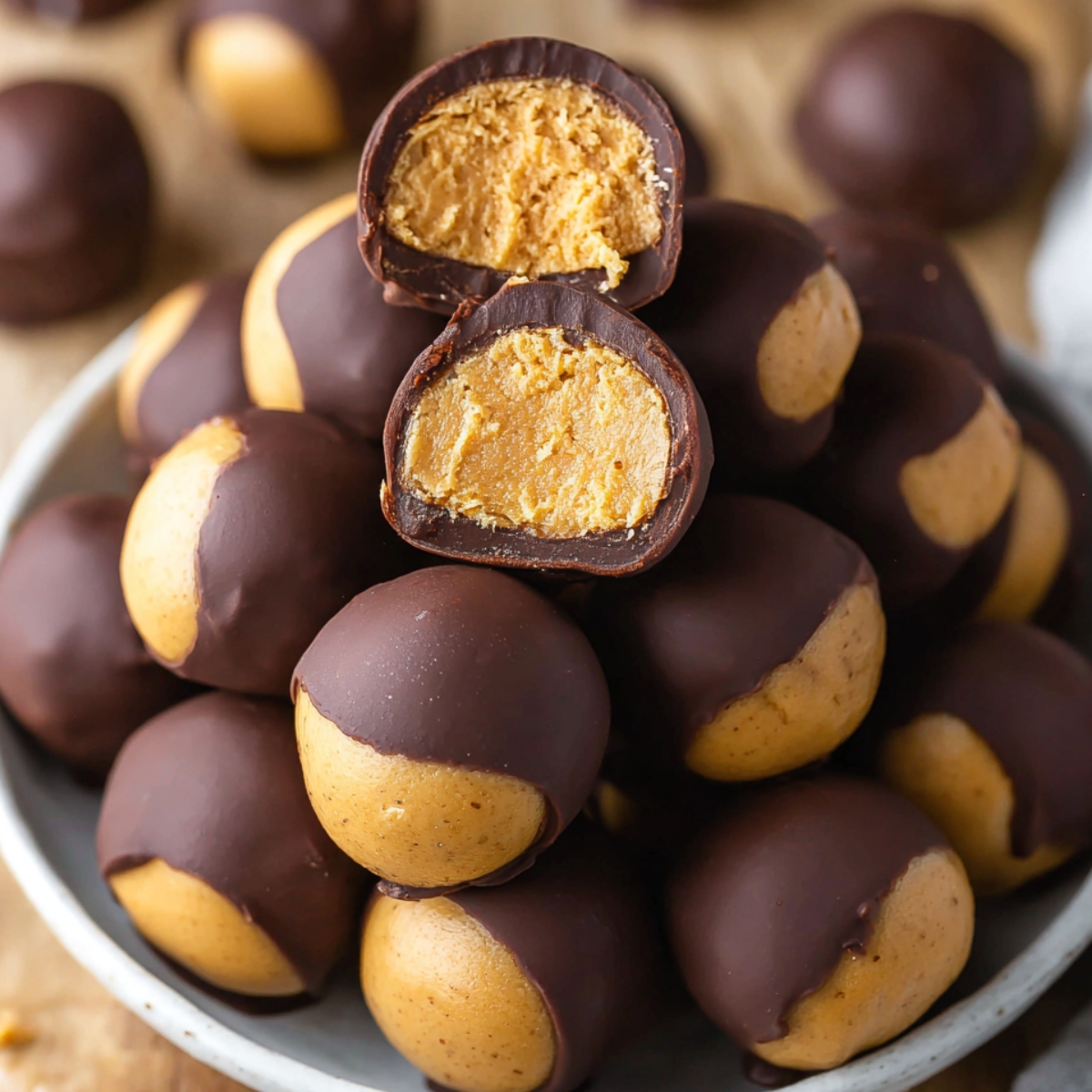 Easy Homemade Buckeyes Recipe 9 Close-up of homemade Buckeyes Recipe, chocolate-covered peanut butter balls with a bite taken out, showing the smooth peanut butter filling.