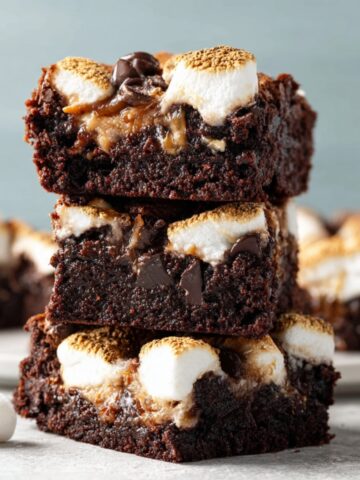 Easy Marshmallow Swirl Brownies Recipe 1 A stack of marshmallow brownies with gooey marshmallow and melted chocolate chips inside, topped with toasted marshmallows.