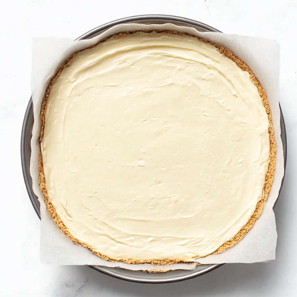 Easy Cheesecake Bars Recipe 11 Smooth and creamy cheesecake filling evenly spread over a graham cracker crust, ready to be baked.