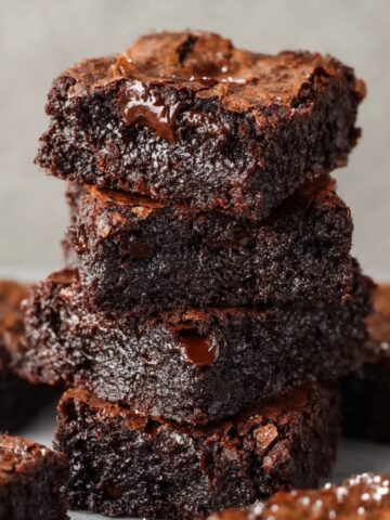 Fudgy Small Batch Brownies Recipe 2 Decadent stack of fudgy Small Batch Brownies, with visible cracks on the top and gooey melted chocolate chunks peeking through.