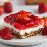 serving of Strawberry Pretzel Salad with a pretzel crust, cream cheese layer, and topped with fresh strawberries and gelatin.