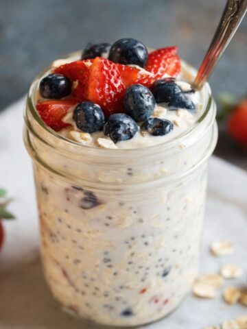 Easy Vanilla Overnight Oats Recipe 8 A jar of Vanilla Overnight Oats topped with fresh blueberries and strawberries, ready to be enjoyed as a nutritious and delicious breakfast.