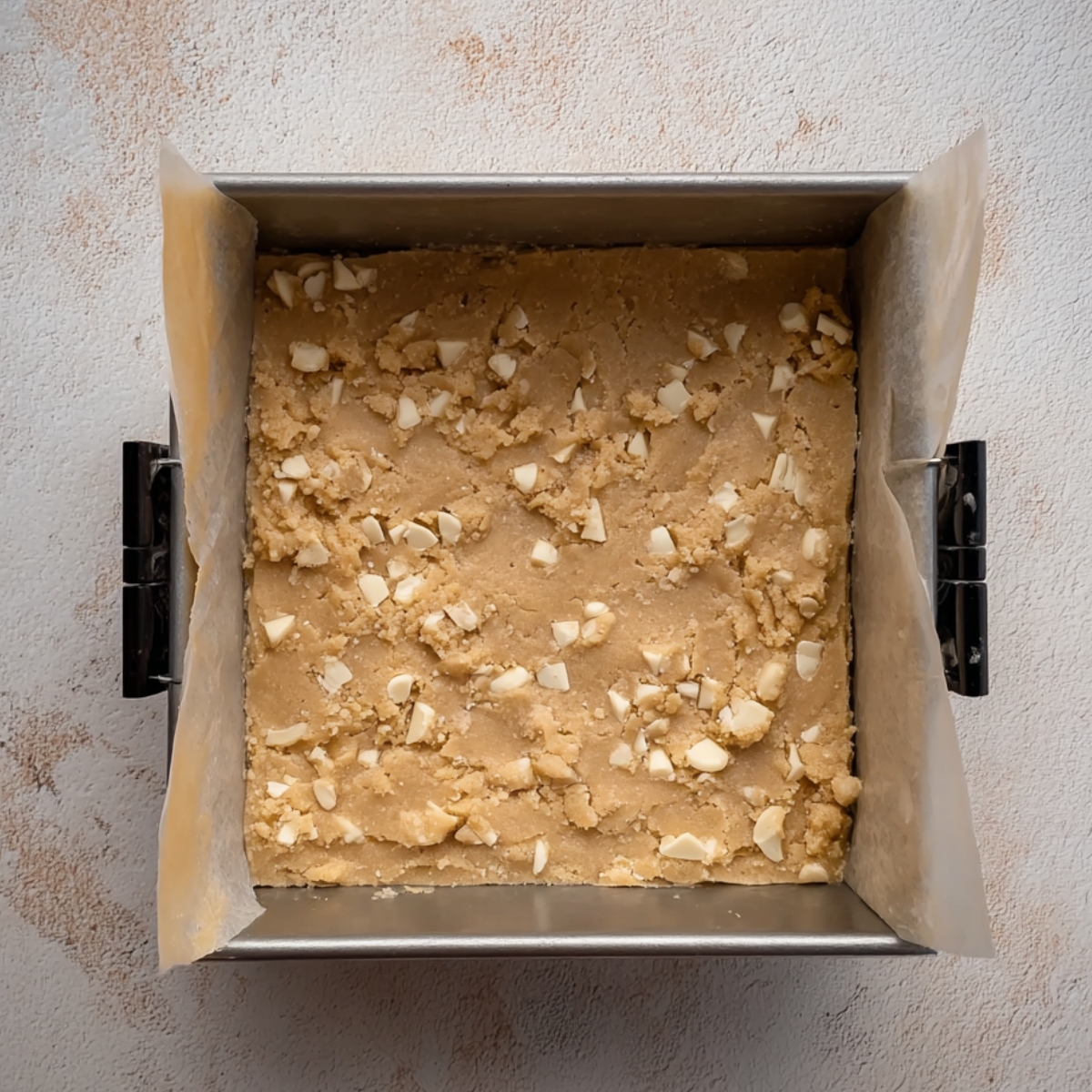 Starbucks Lime Frosted Coconut Bars 11 Cookie dough with white chocolate chunks in a baking pan, ready to bake.