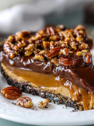 The Best Caramel Turtle Pie Recipe 1 Slice of Caramel Turtle Pie topped with pecans and a glossy layer of chocolate.