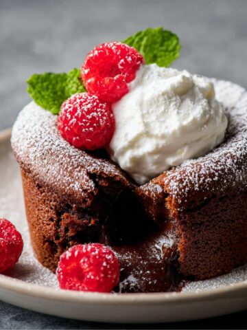 The Best Chocolate Soufflé Recipe 5 A decadent Chocolate Soufflé topped with fresh raspberries, mint leaves, and a dusting of powdered sugar, with a gooey center.