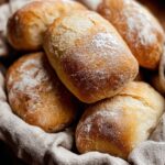 Freshly baked Ciabatta Bread in a basket, with a rustic, golden crust and soft interior, lightly dusted with flour.