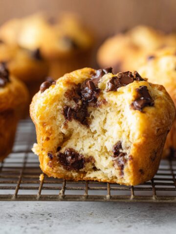 Healthy Cottage Cheese Muffins Recipe 2 A close-up of a freshly baked Cottage Cheese Muffins with chocolate chips, showing a bite taken out to reveal the fluffy interior and melted chocolate chips.